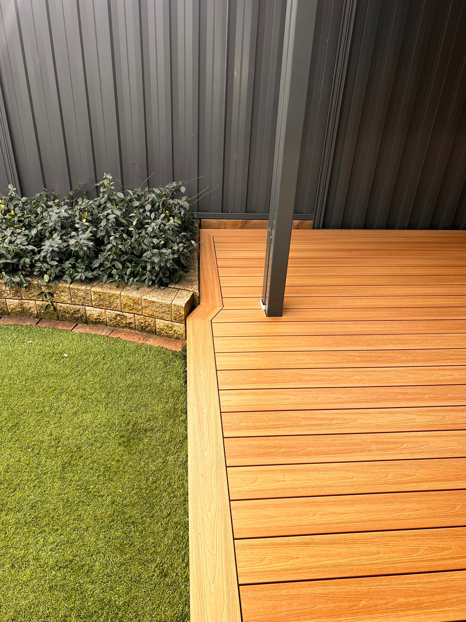 Ground-level view of poolside pergola and composite deck, McKellar Canberra